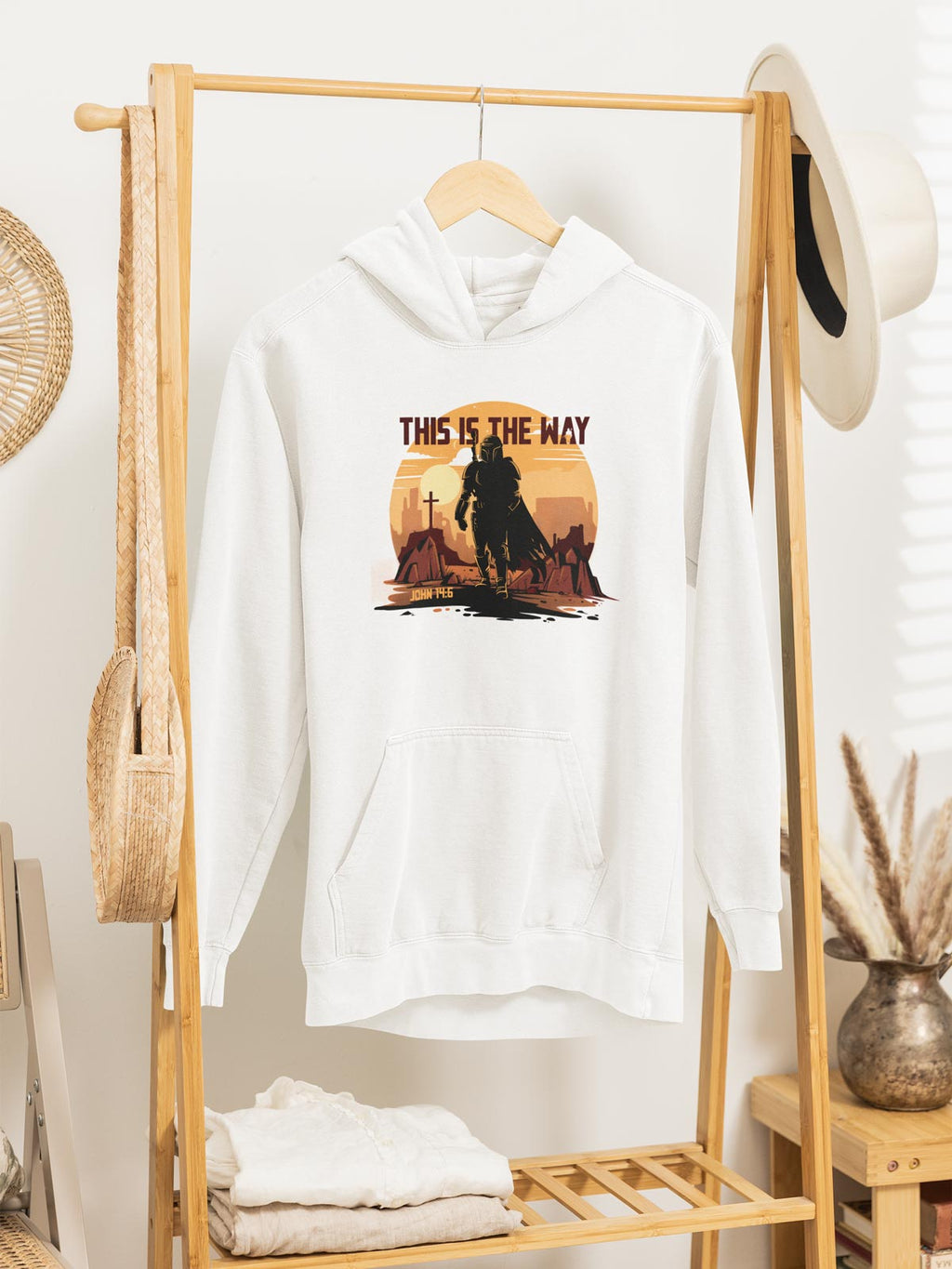 White hoodie with 'This is the Way' graphic on a wooden rack.