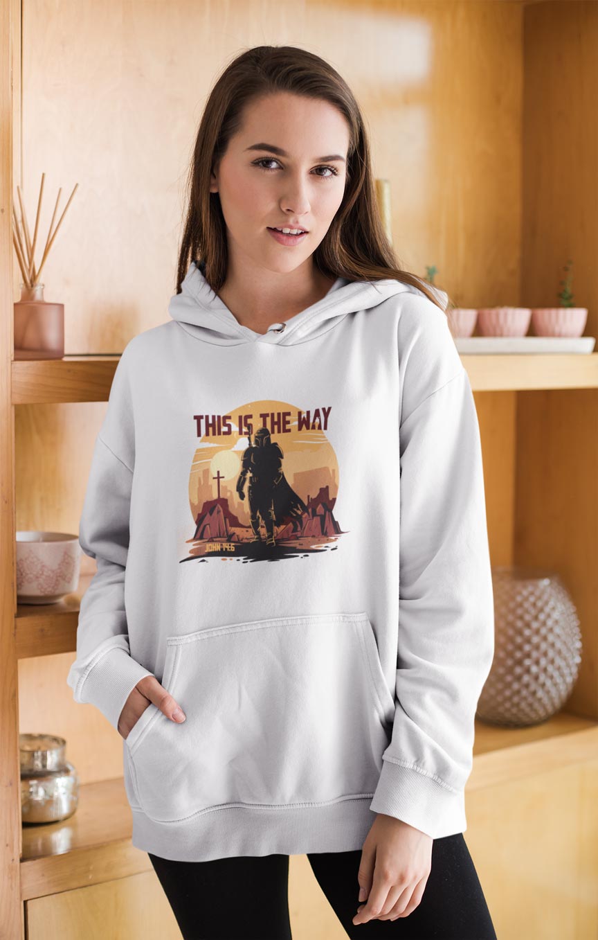woman wearing a hoodie with a graphic design and text in a room with wooden shelves.